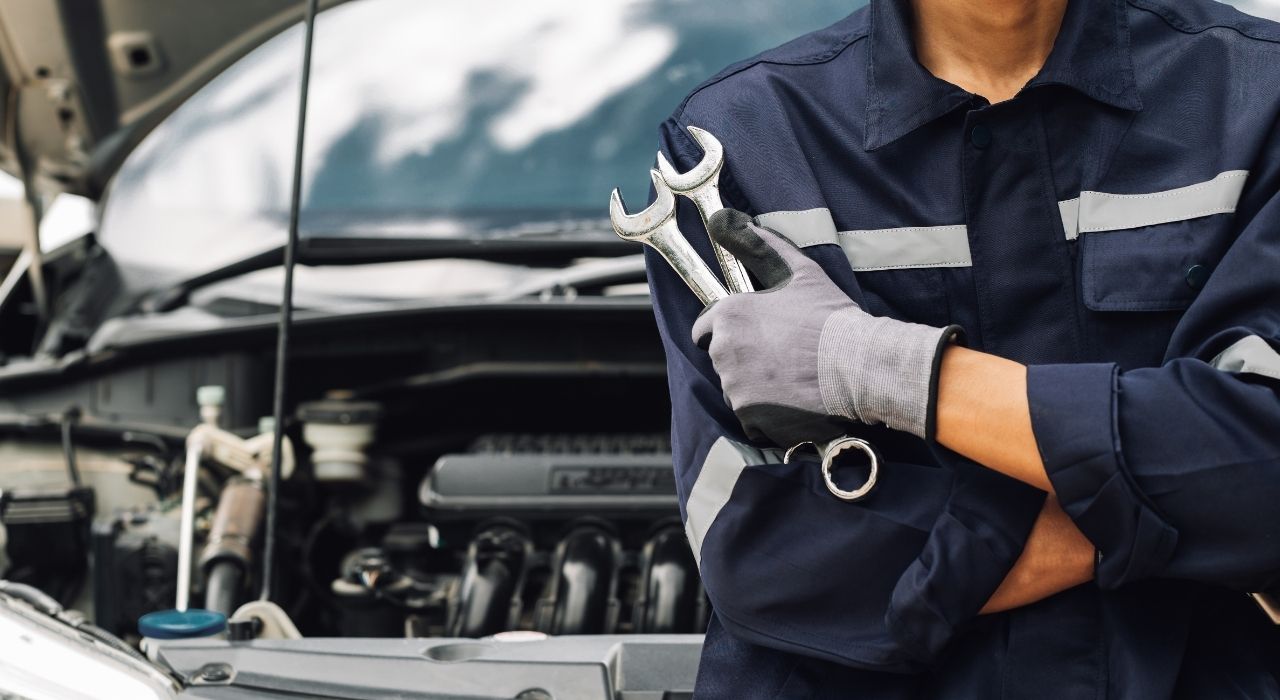 Automechaniker, der kontrolliert warum Motorklopfen entsteht