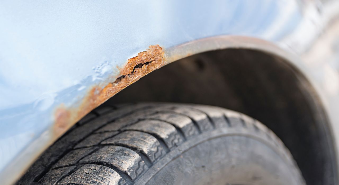 Hellblaues Auto mit Roststellen über dem Rad