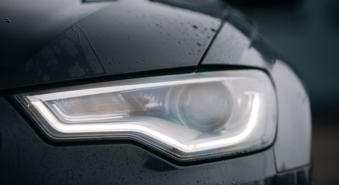 Scheinwerfer eines schwarzen Autos im Regen